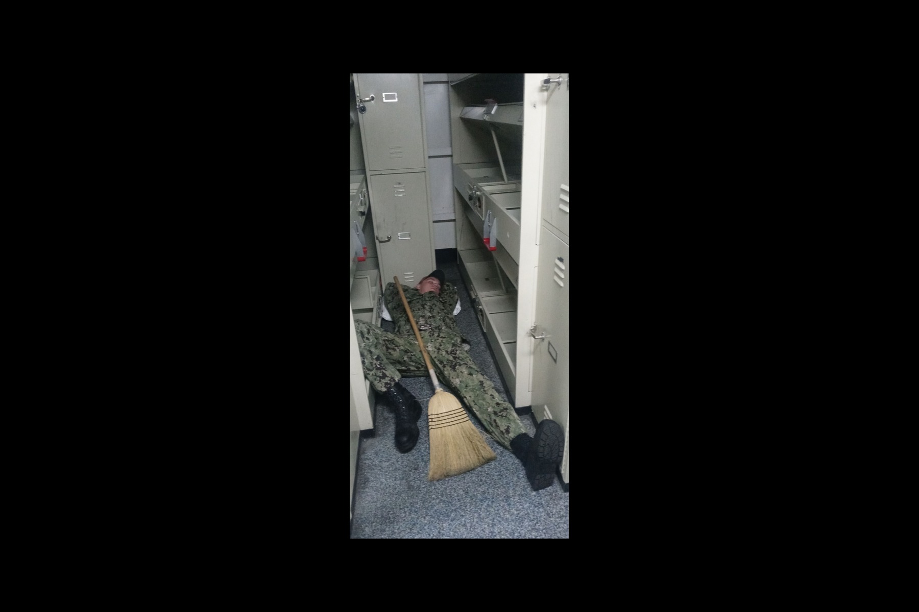 A sailor sleeping during cleaning stations.